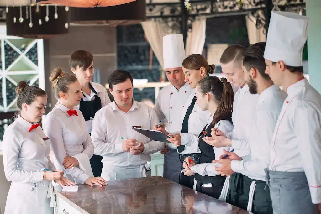 restaurant-manager-his-staff-terrace-interacting-head-chef-restaurant